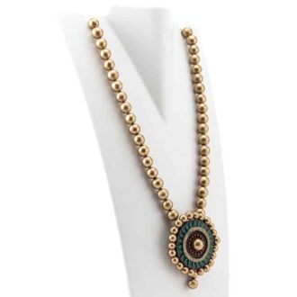 Antique gold bead string flank a handmade pendant with gold, green and red accents